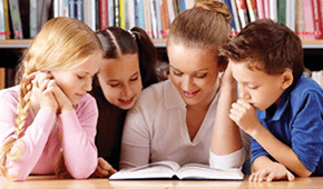 בחורה ושלושה ילדים קוראים יחדיו ספר, ומאחוריהם מדפי ספרים