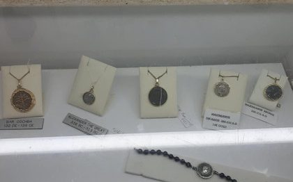 תכשיטים עם תליונים כסף ואבני חן, מוצגים על ניירות תווית.