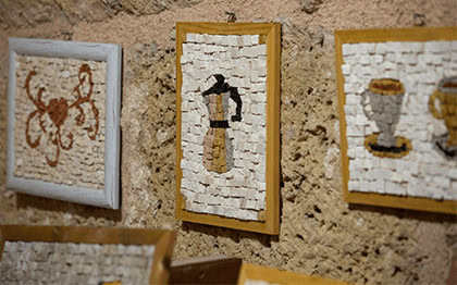 שלטי קיר עם עיצובים של חפצים עתיקים על קיר אבן, תערוכת א.
