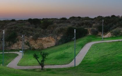 אזור גבעות נמוכות מכוסה דשא, ושביל הליכה מתפתל עובר בו, ולצידו עמודי תאורה. בחלק המרוחק של התמונה ניתן לראות שטח גבעות דומה ללא דשא, אלא מכוסה צמחייה טבעית.