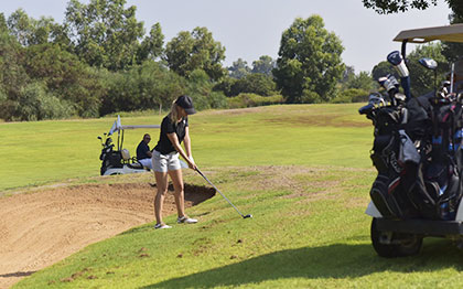 אישה חובטת בכדור גולף במגרש גולף