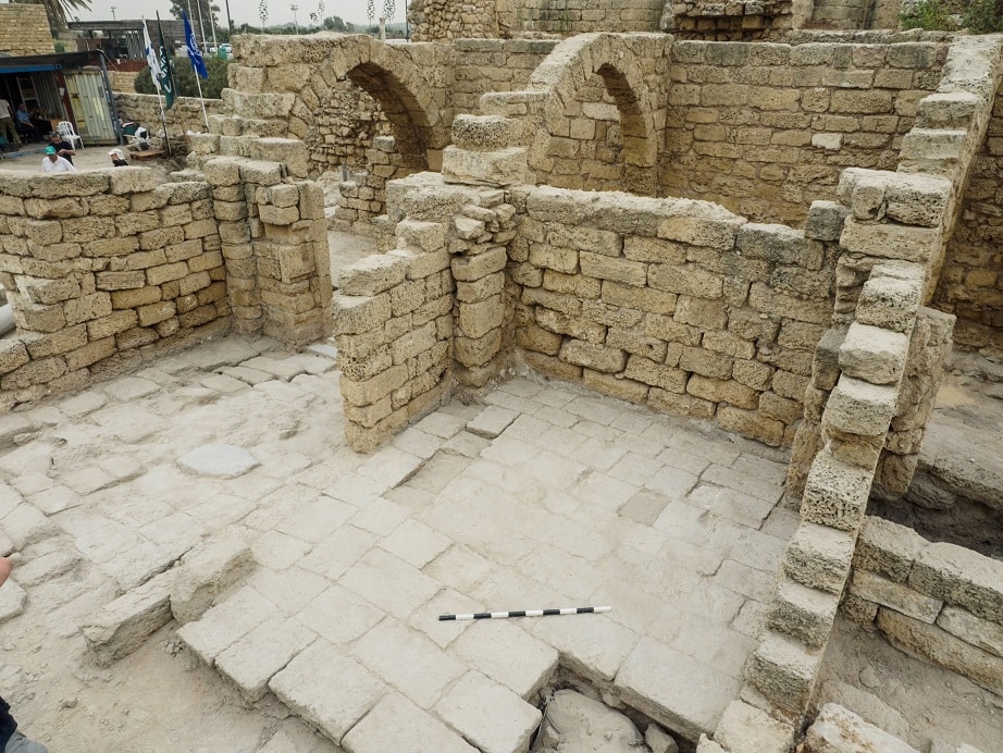 תצלום של שרידי מבנים: קירות הבנויים מאבנים, רצפות המרוצפות גם הן מאבנים מסותתות, וקמרונות אבן