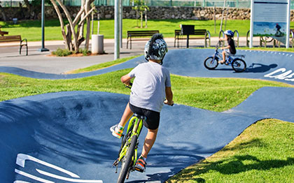 שני ילדים רוכבים על אופניים במסלול הפאמפפארק.