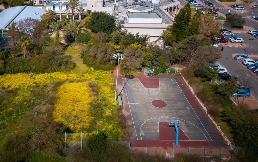תצלום מן האוויר של מגרש כדורסל ואזור חנייה