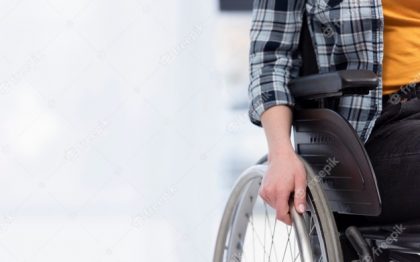 תצלום חלקי של אישה יושבת על כיסא גלגלים כשידה הימנית אוחזת בגלגל הימני של הכיסא