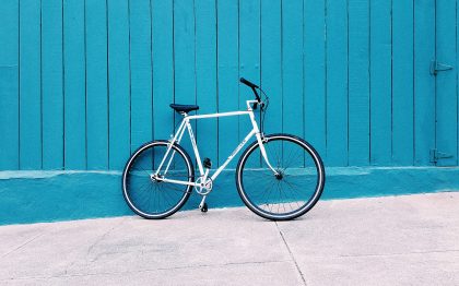 אופניים שעונים על גדר עץ כחולה