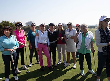 קבוצה של נשים עומדות עם מחבטי גולף