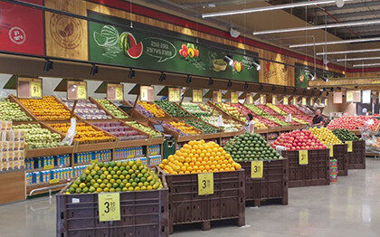 חנות גדולה למכירת פירות וירקות מסודרים בצורה נאה בארגזים ובמדפים