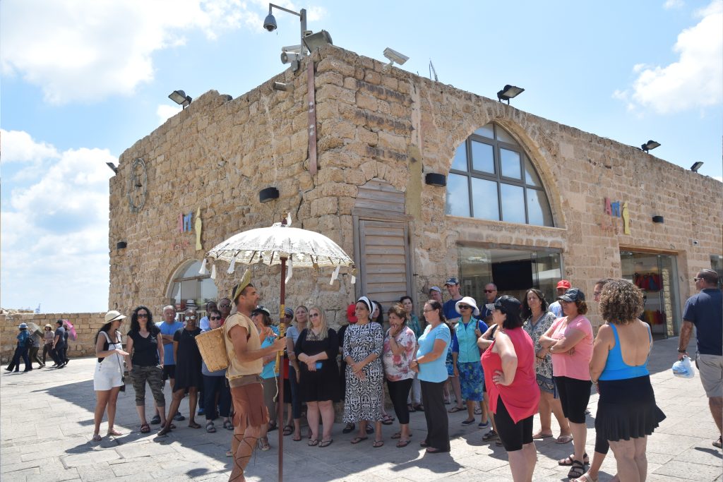 שלט חוצות של החברה לפיתוח קיסריה עם קבוצה של מבקרים בחו.
