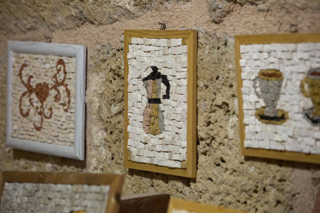 יצירות אמנות מקרמיקה על קיר אבן עתיק, תערוכת אמנות בקיס.