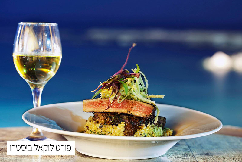 מנות גורמה עם יין לבן על רקע נוף ימי מרהיב.
