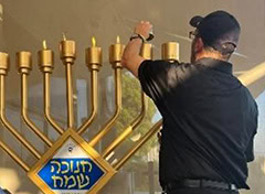 אדם מצלם את חנוכת חנוכייה גדולה בקיסריה, אירוע חגיגי ומ.